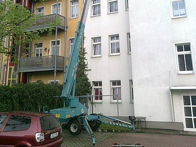Anhänger-Arbeitsbühne von Hochtec an der Fassade eines Wohnhauses im Hinterhof