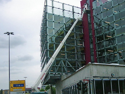 Arbeitsbühne an der Glasfassade eines modernen Gebäudes
